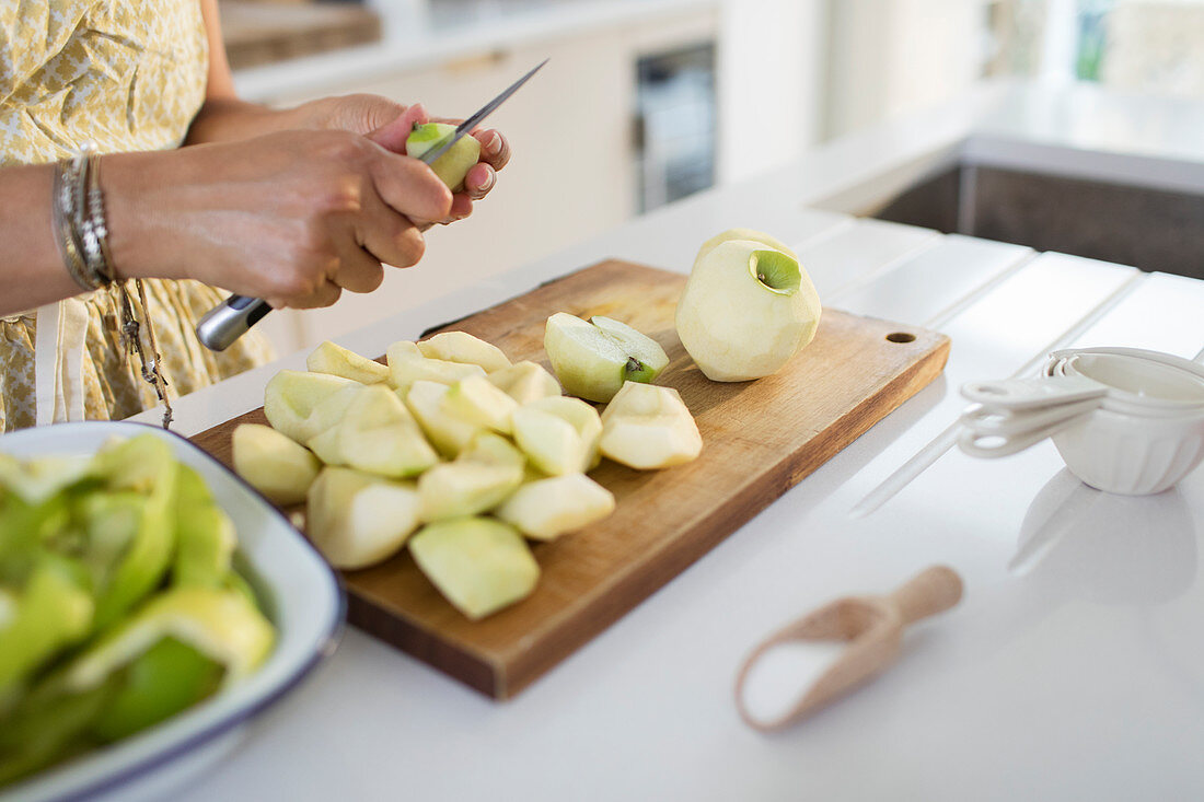 Woman slicing green apples for baking