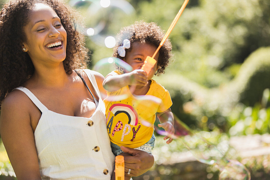 Happy mother and toddler daughter playing