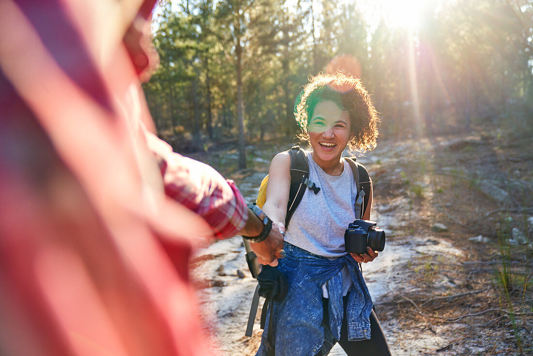 Happy couple hiking with camera in sunny woods