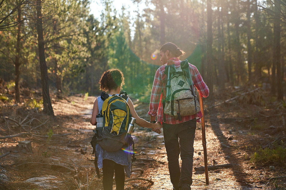 Young couple hiking with backpacks in summer woods