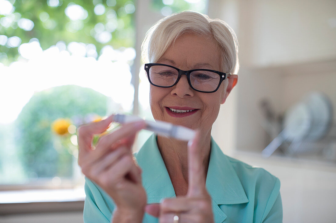 Woman with diabetes using blood glucose meter