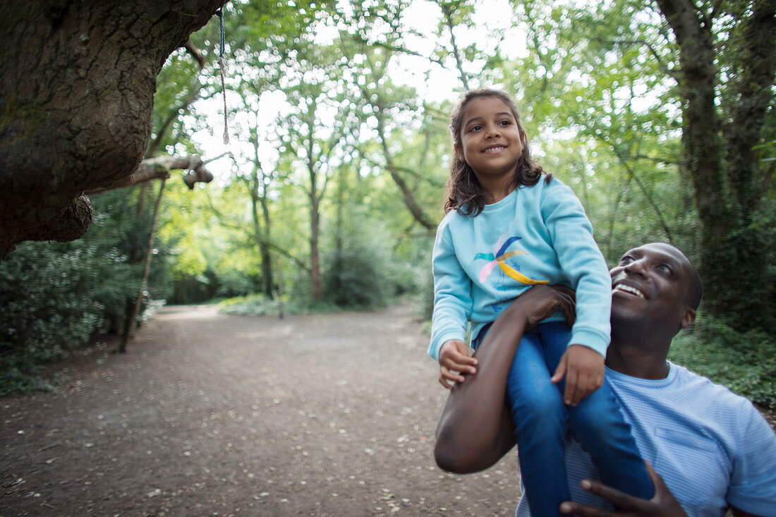 Happy father and daughter on path in woods