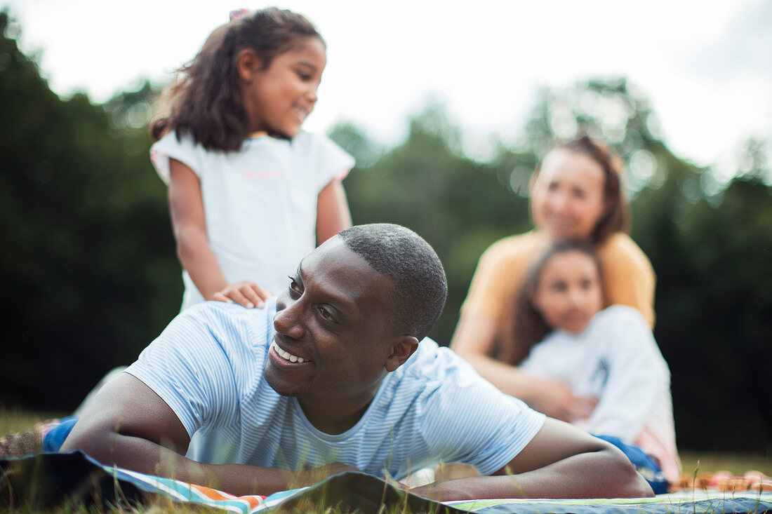 Happy man enjoying picnic in park with family