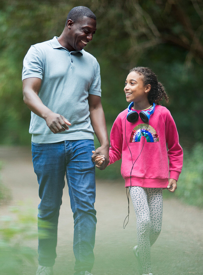 Father and daughter holding hands walking