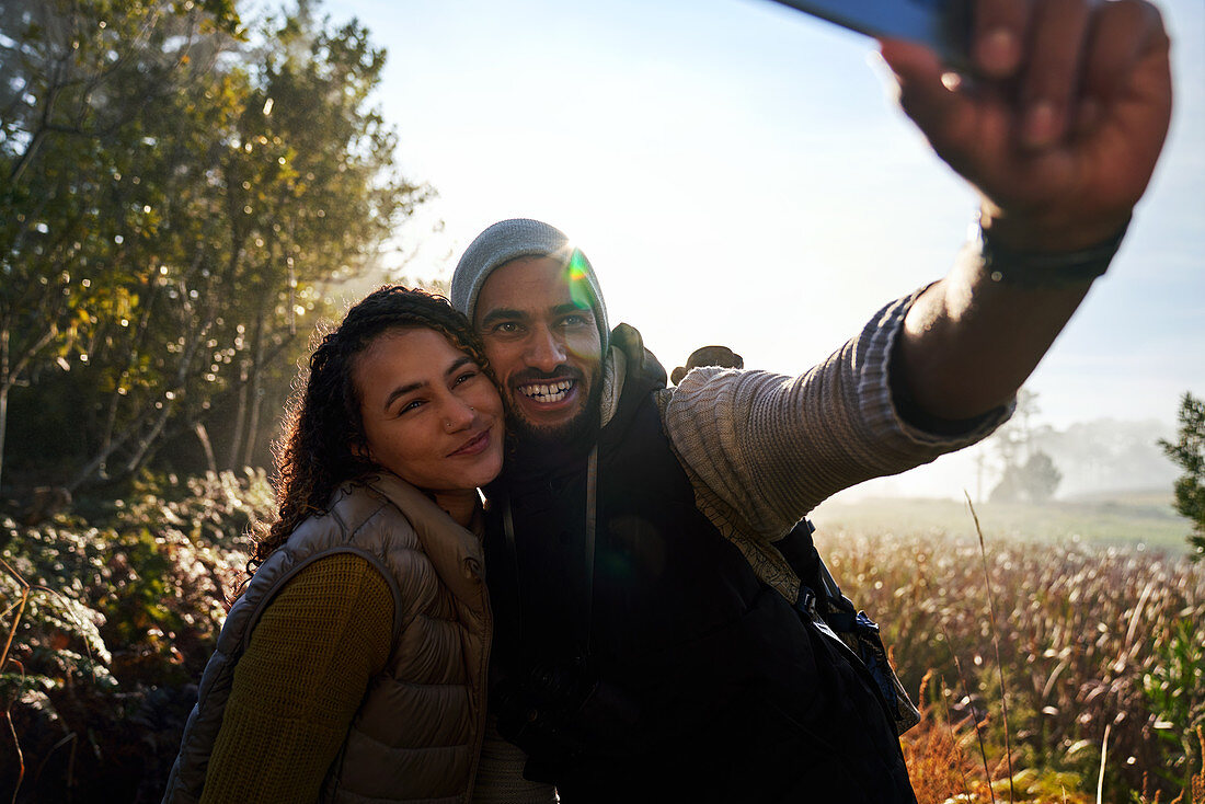 Happy young couple taking selfie on hike