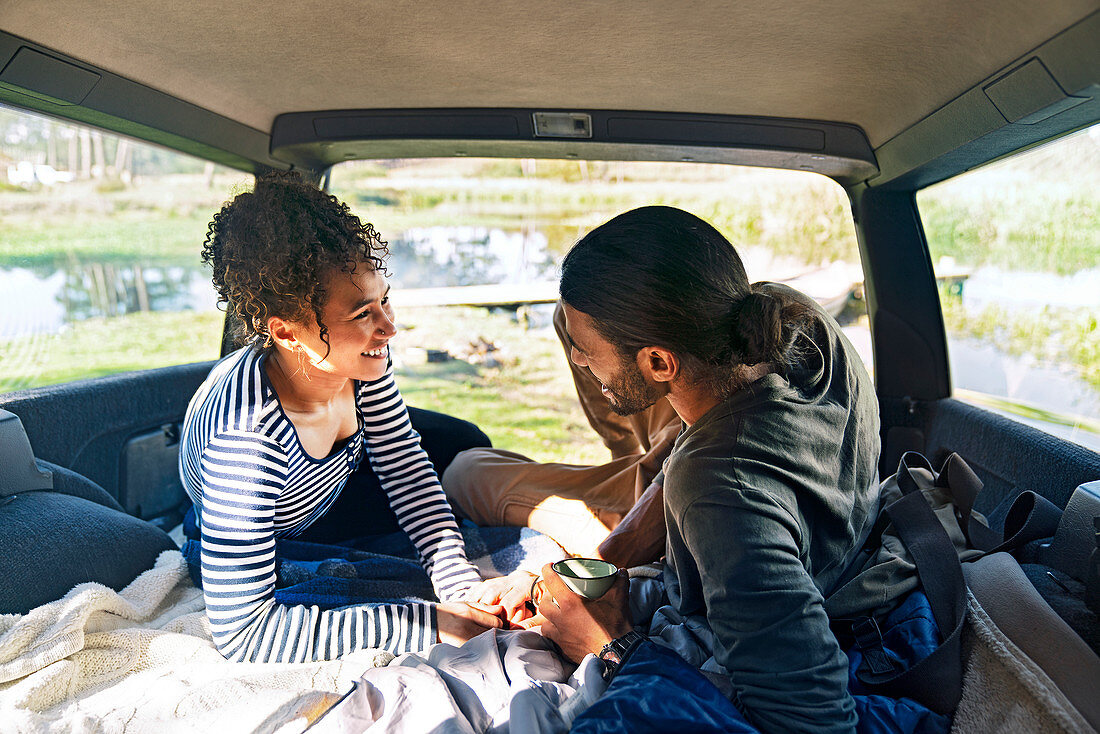 Couple relaxing in back of car on road trip