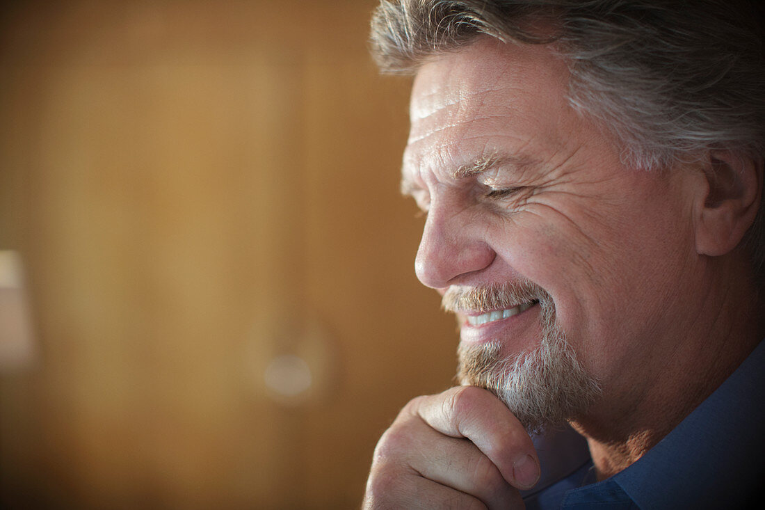 Close up smiling senior man with hand on chin