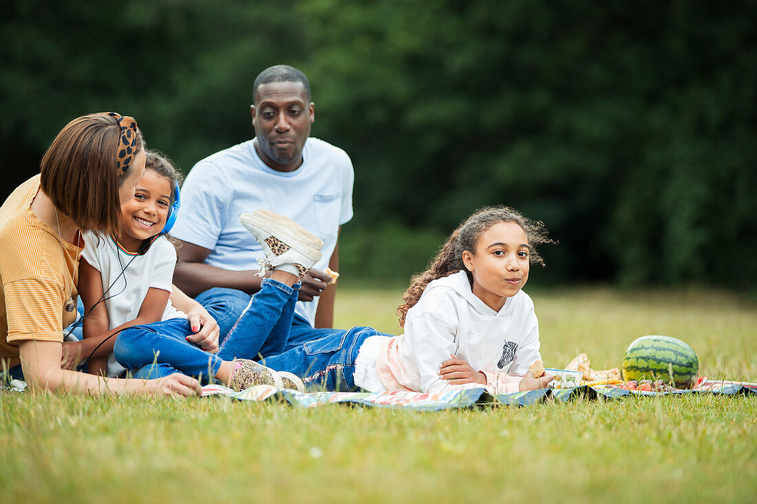 Family relaxing and enjoying picnic in park