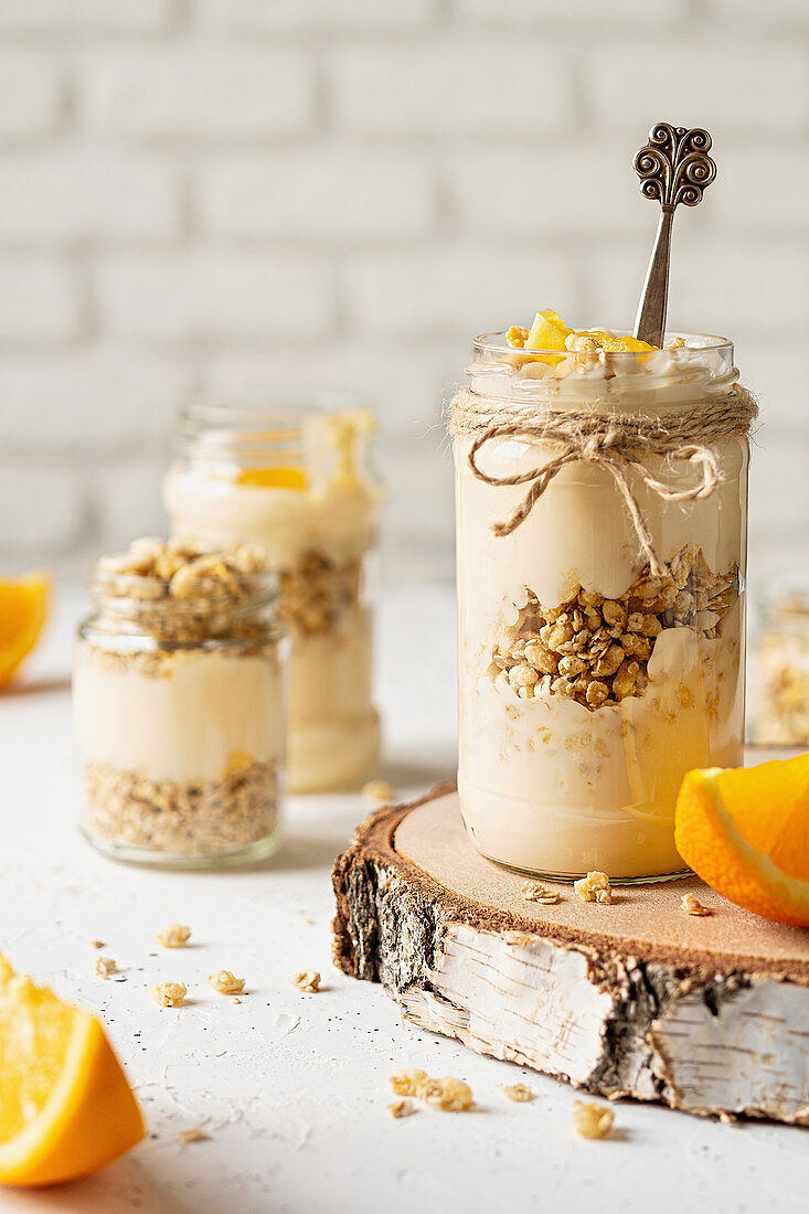 Orangenjoghurt mit Müsli in Gläsern