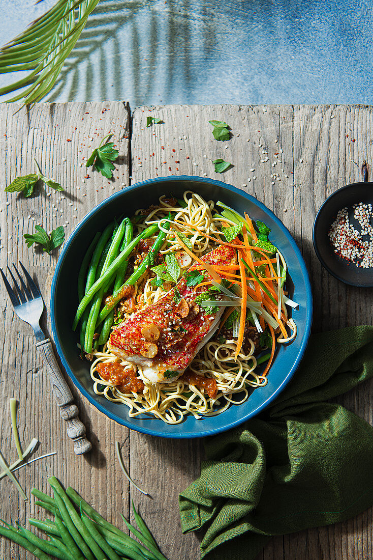 Oriental noodles with chilli jam, beans, herbs and grilled red snapper