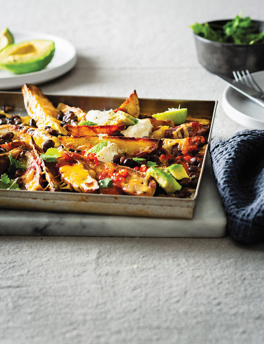 Süßkartoffelspalten vom Blech mit Bohnen, Avocado und Käse