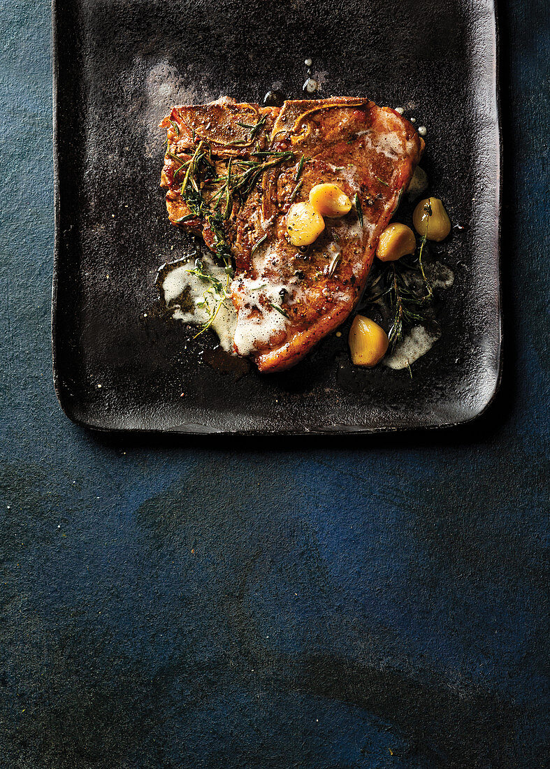 Herby t-bone steak with garlic confit