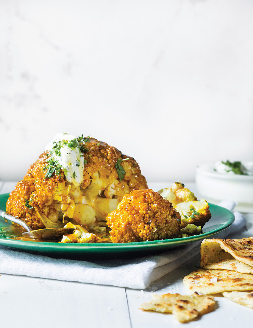 Apricot and turmeric whole roasted cauliflower with yoghurt and flatbreads