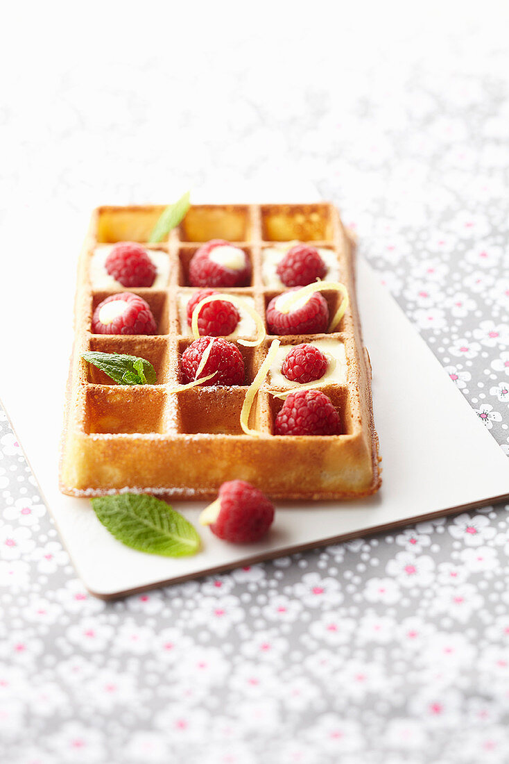 A waffle with lemon cream and raspberries