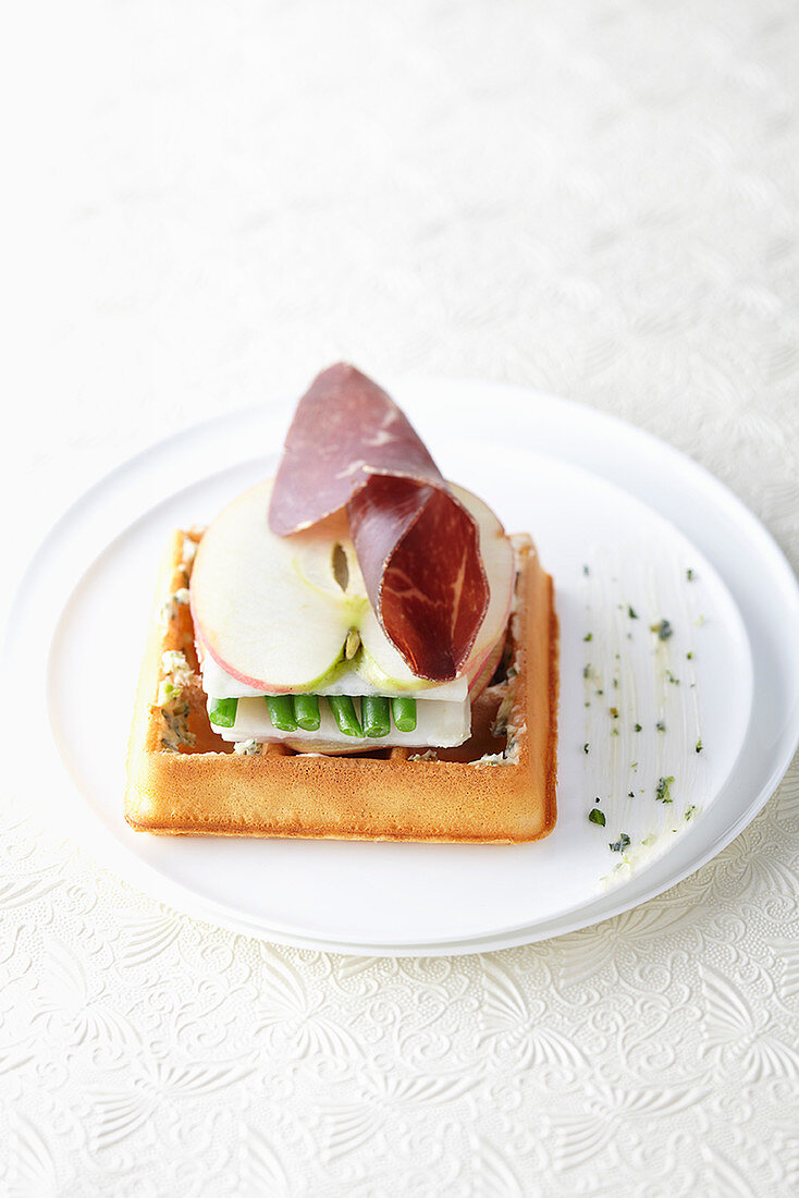 A waffle with bresaola, apple and beans