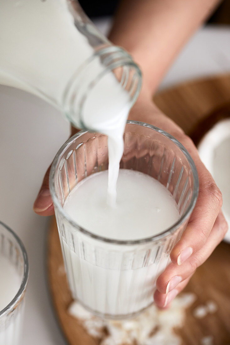 Pouring homemade coconut milk in the glass
