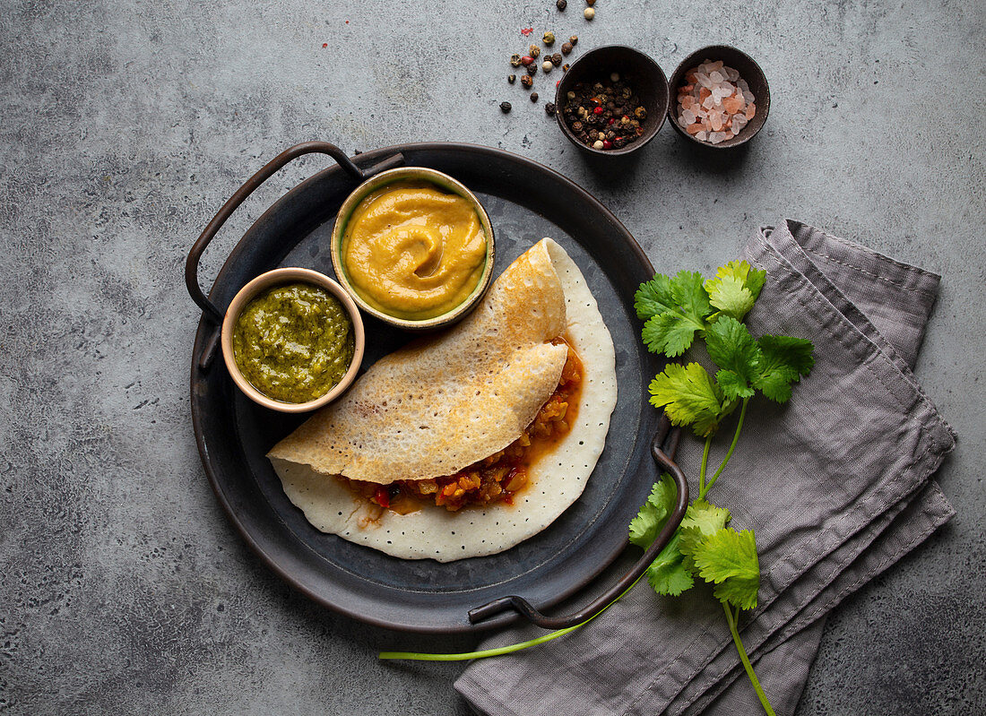 Traditional Indian rice pancakes Dosa with different dips chutney and seasonings