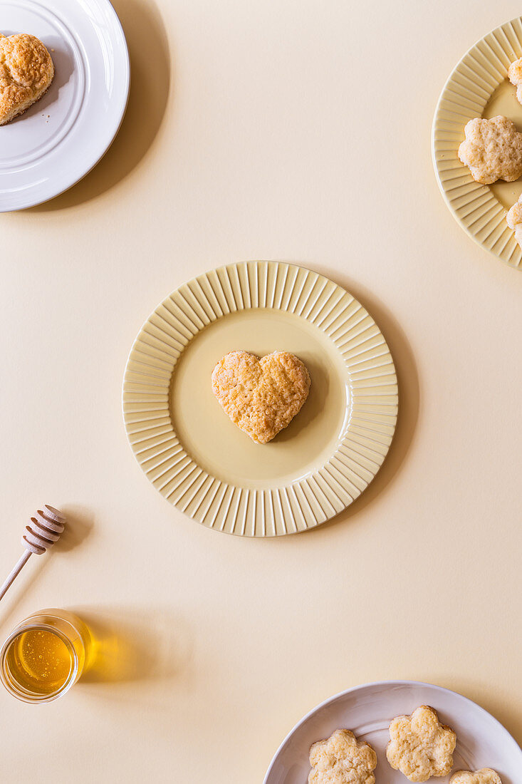 Homemade scones in shape of heart and flowers served with aromatic natural honey