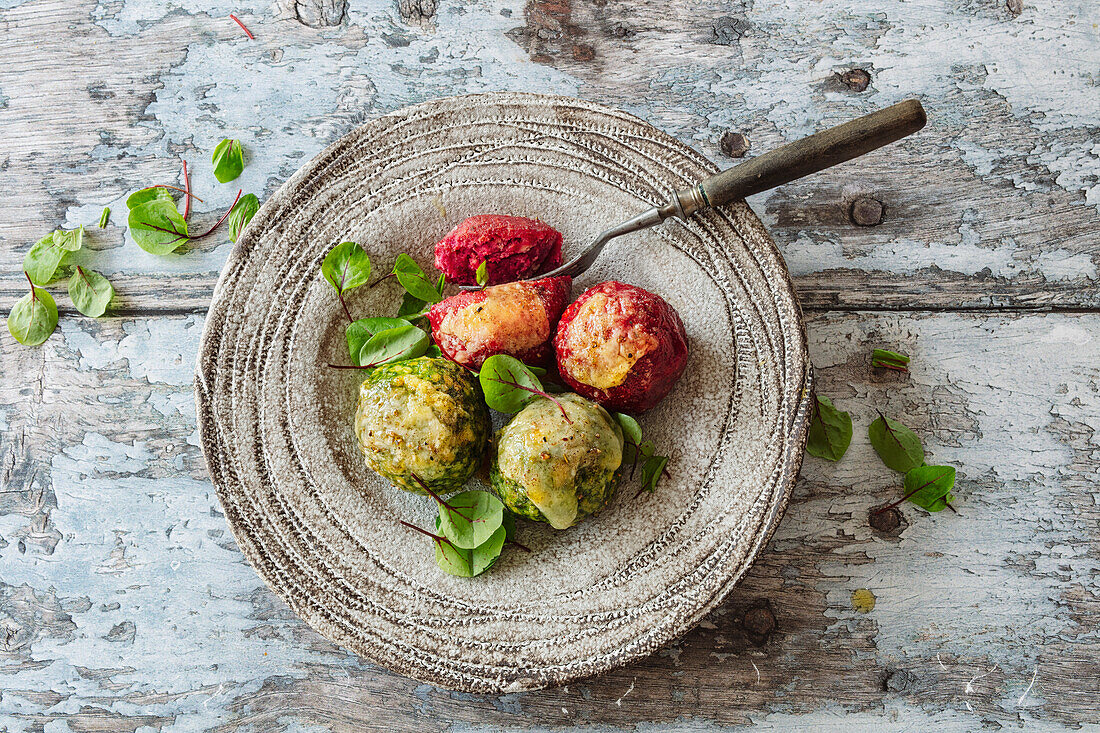 Raw bean dumplings and spinach dumplings gratinated with parmesan cheese