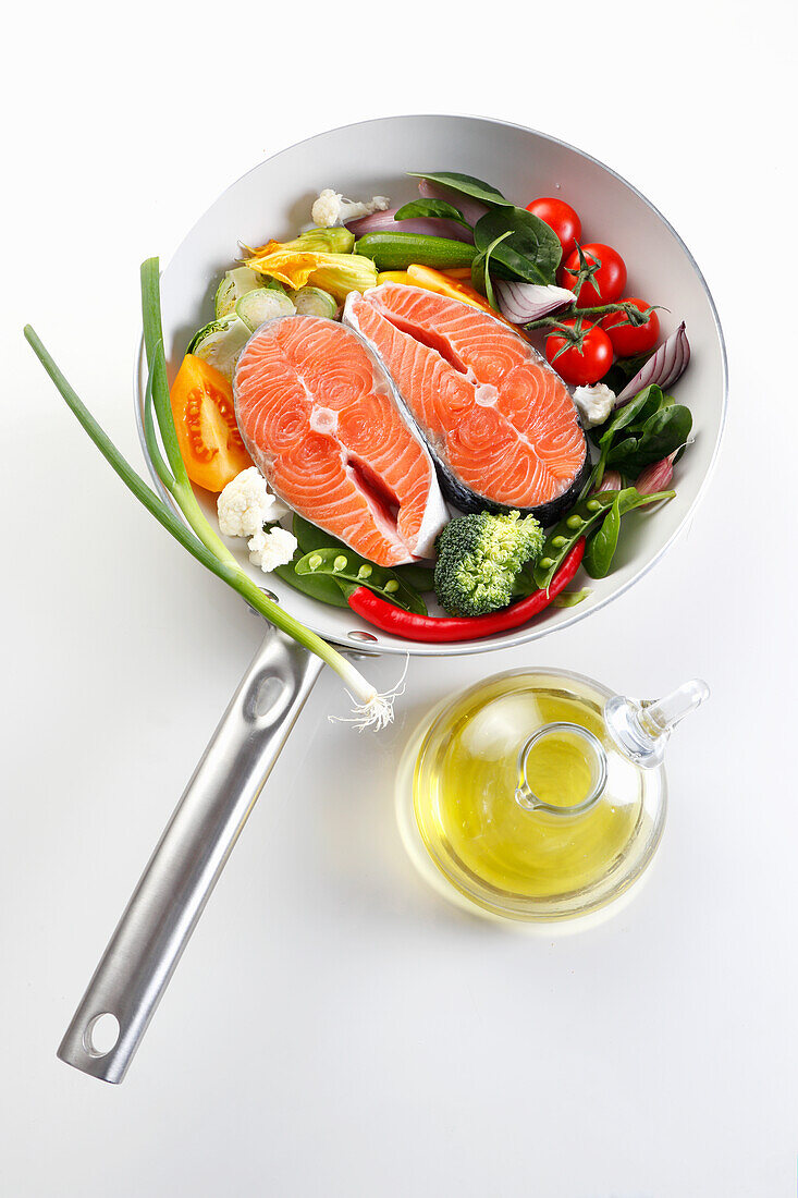 Frying pan with fresh salmon and fresh vegetables