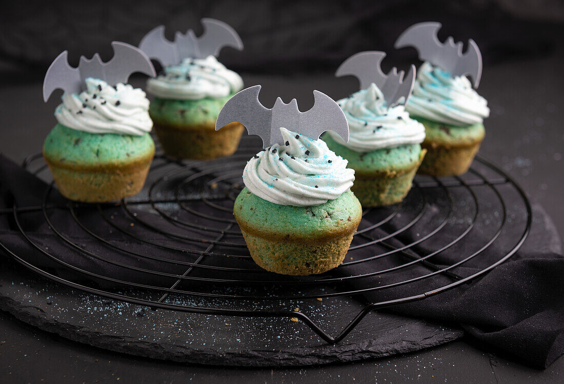 Vegan cupcakes with rice light chocolate cream and wafer decoration on cooling rack for Halloween