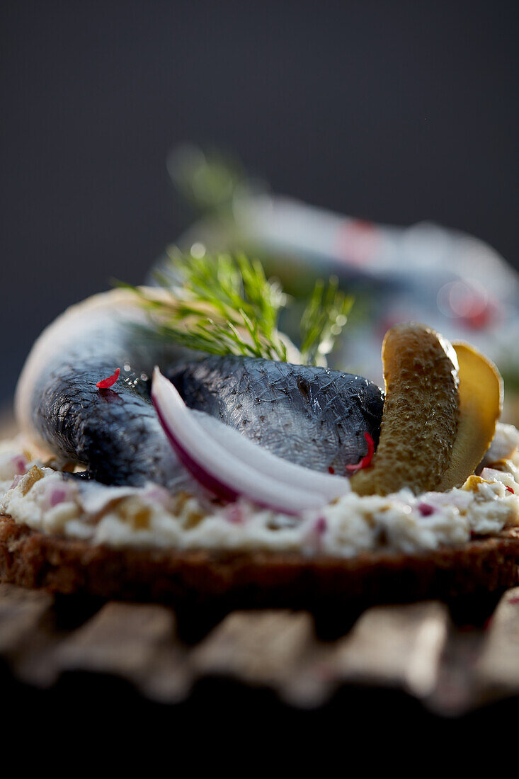 Rollmop herring with gherkins and onion on pumpernickel rounds