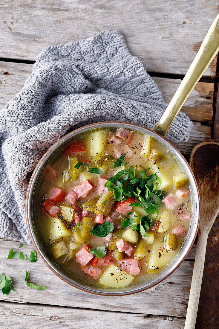 Sour potato pieces with cabanossi and gherkins