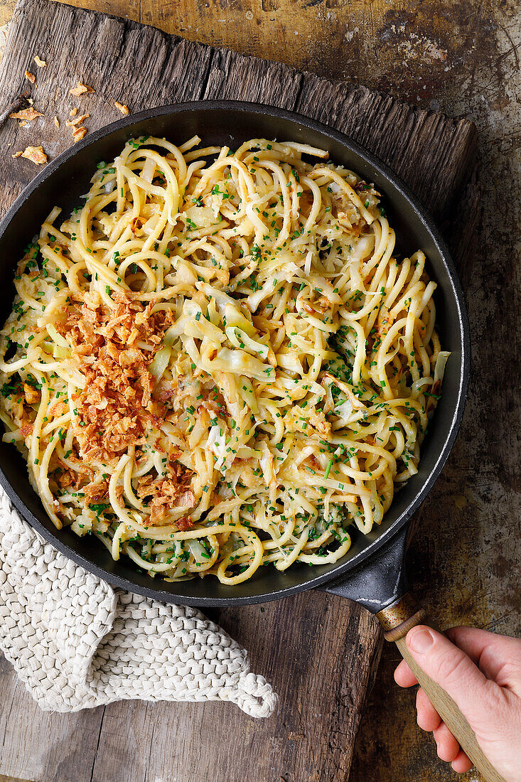 Macaroni with white cabbage, apples and mountain cheese in a pan