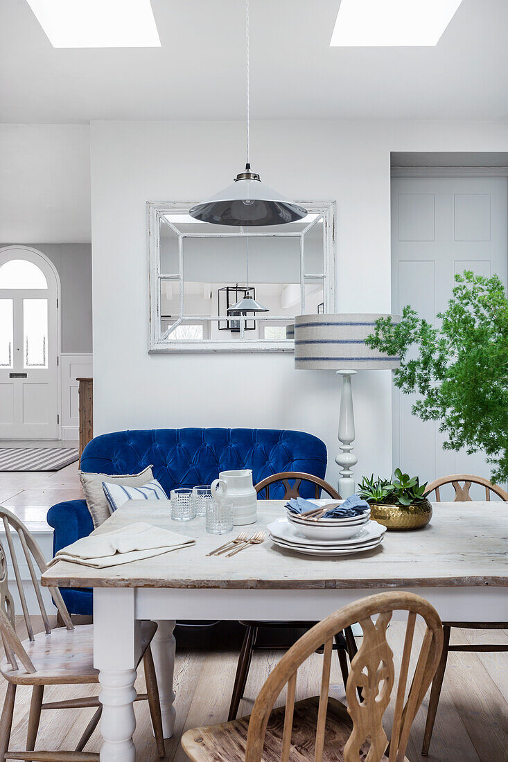 White painted wooden table and chairs in the dining area with skylight