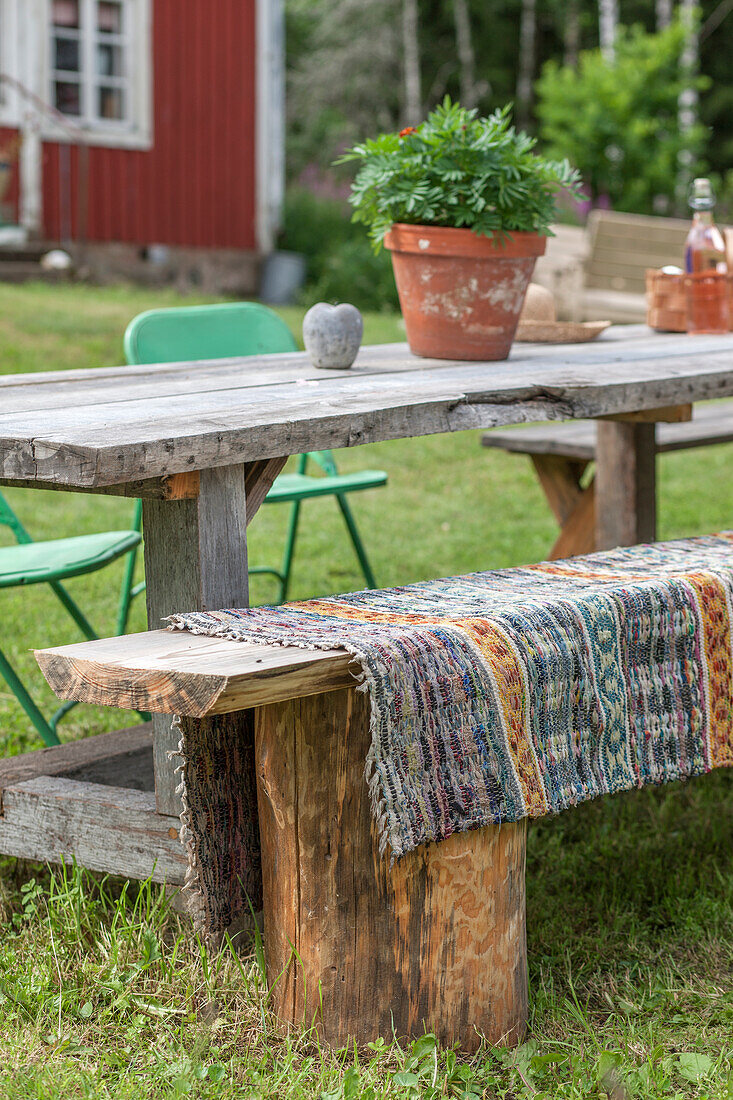 DIY bench made of old tree stumps and board at wooden table