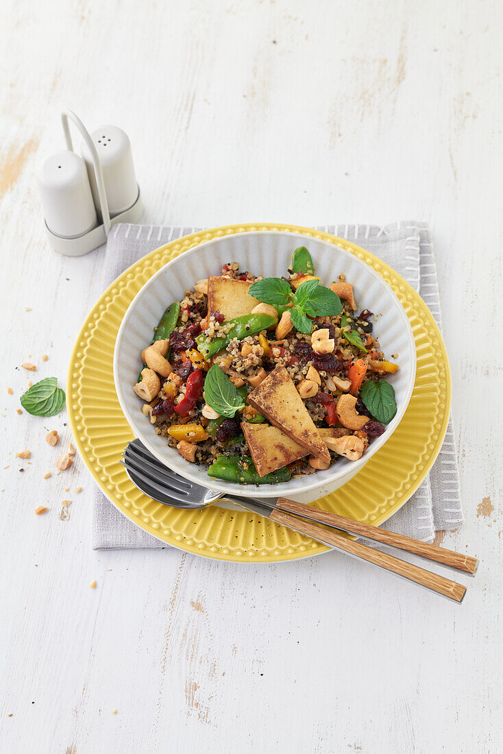 Quinoa salad with vegetables, fried tofu, and mint