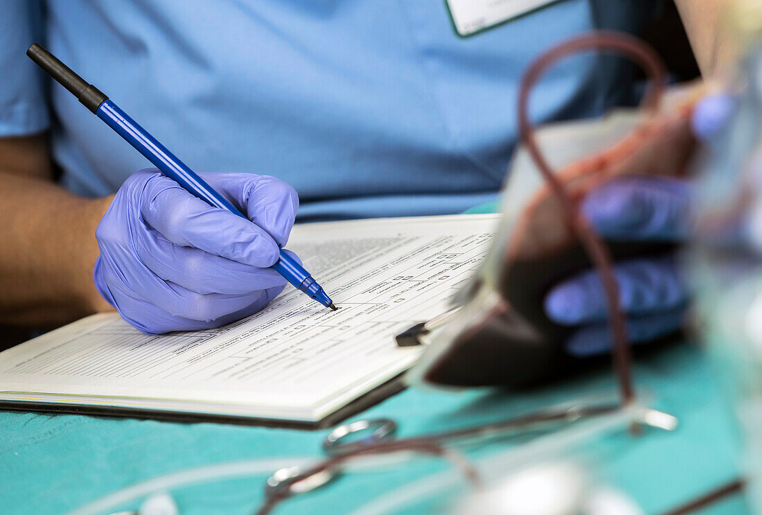 Nurse writing down blood transfusion data