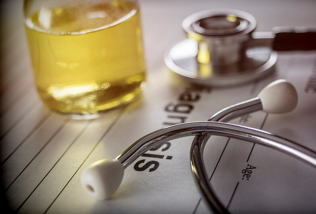 Vial of medication next to a stethoscope, conceptual image
