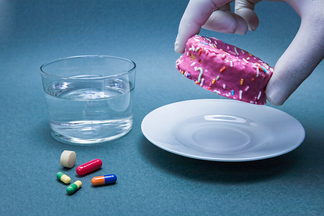 Diabetes medication and a glass of water next to a cake