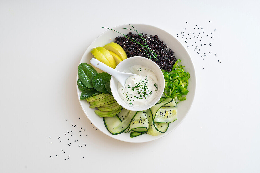 A bowl of black rice, cucumber, apple and avocado