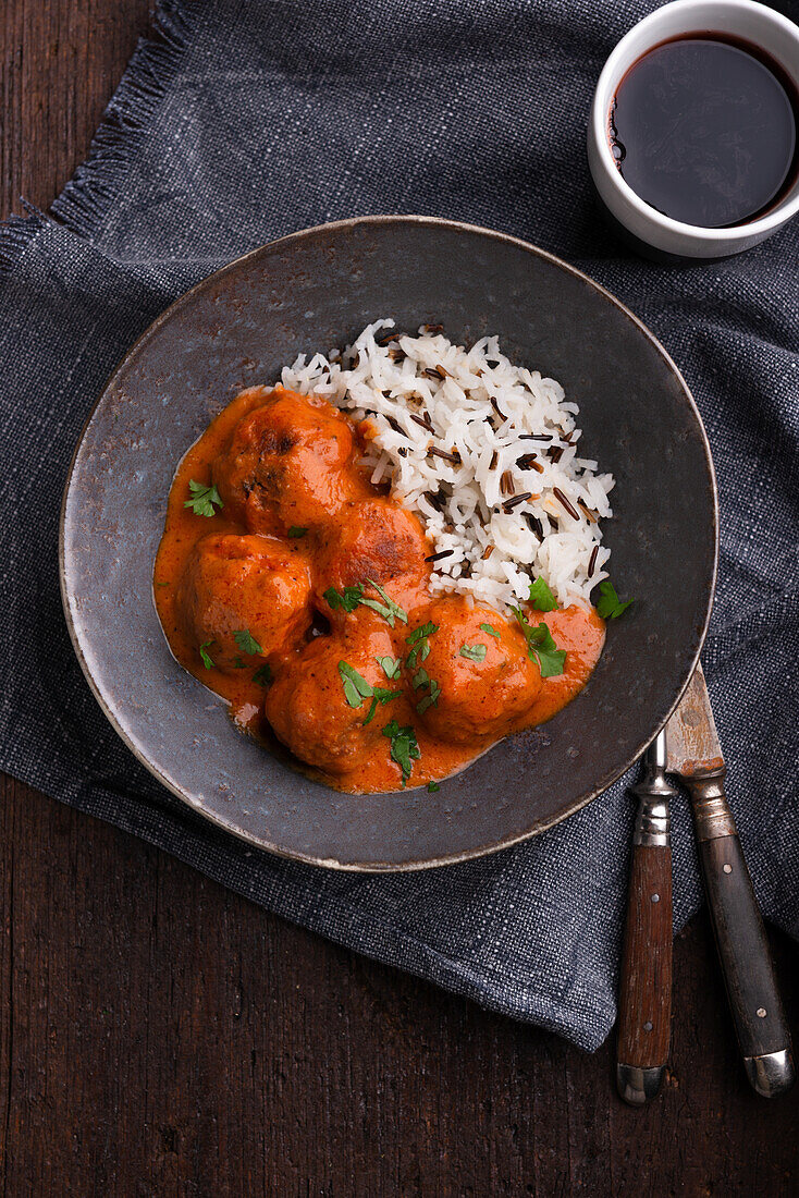 Vegan meatballs in a tomato-and-coconut sauce with a wild rice mix