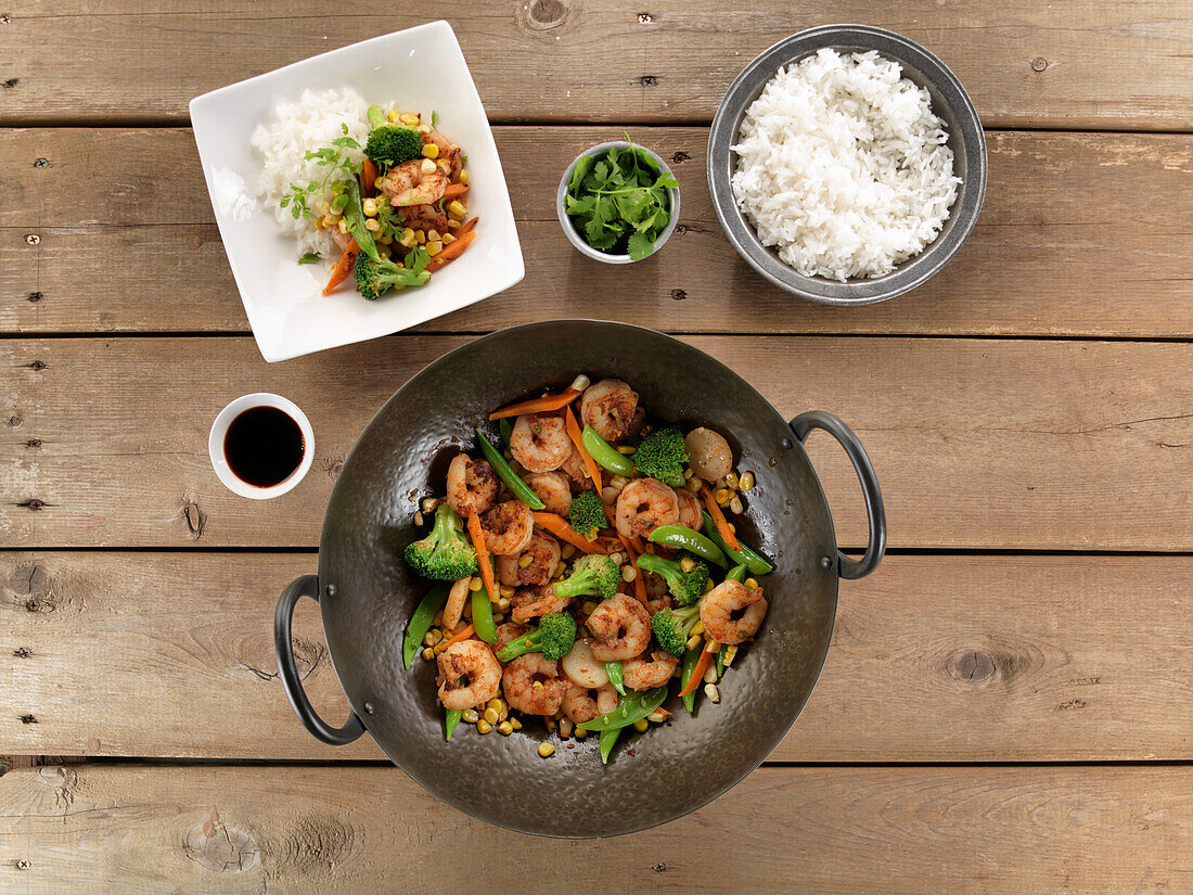 Fried prawns with vegetables in a wok served with rice