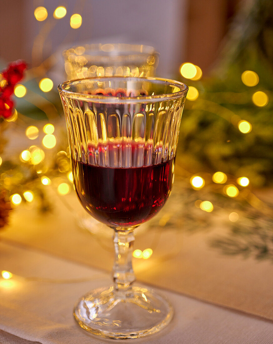 A glass of red wine in a festive setting