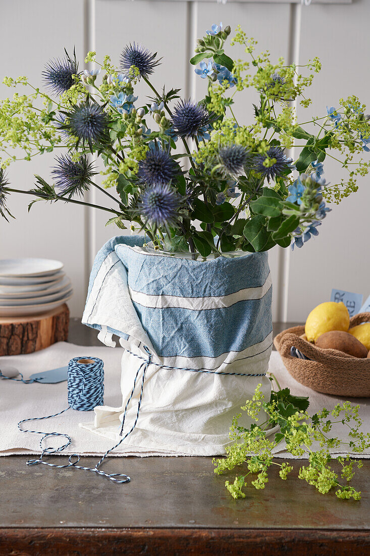 Bouquet of thistles, lady's mantle, and blue silk flower