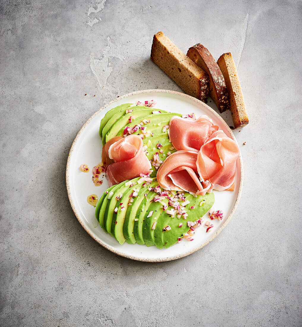 Avocado mit Parmaschinken und roten Zwiebeln