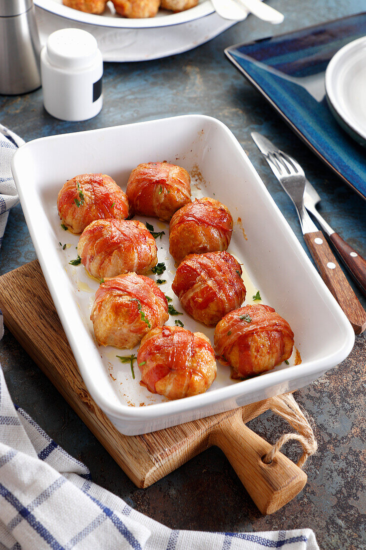 Baked chicken balls, wrapped in slices of smoked bacon