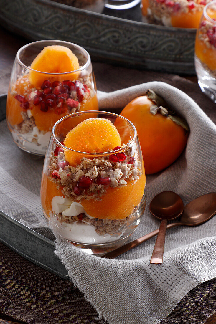 Schichtdessert mit Kaki-Frucht, Schlagsahne und Müsli