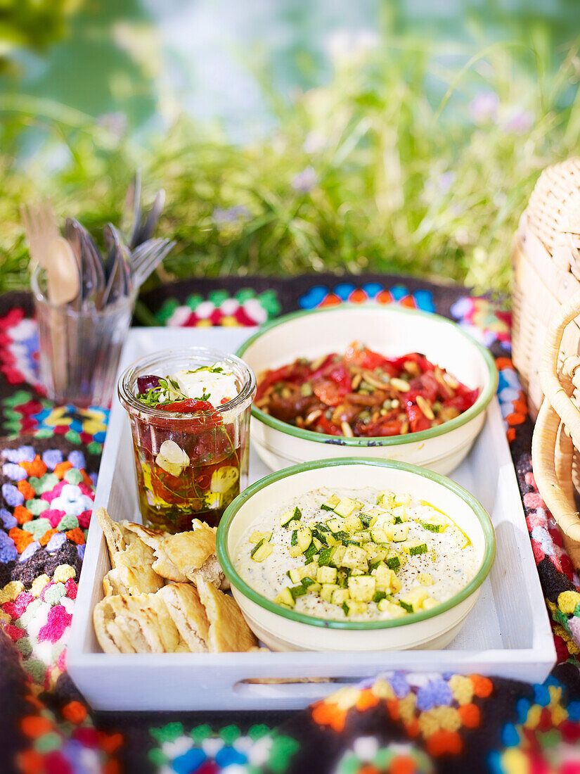 Marinierter Feta in Thymian-Chili-Öl, Röstpaprikasalat und Bohnen-Zucchini-Dip mit Minze und Pita-Crisps