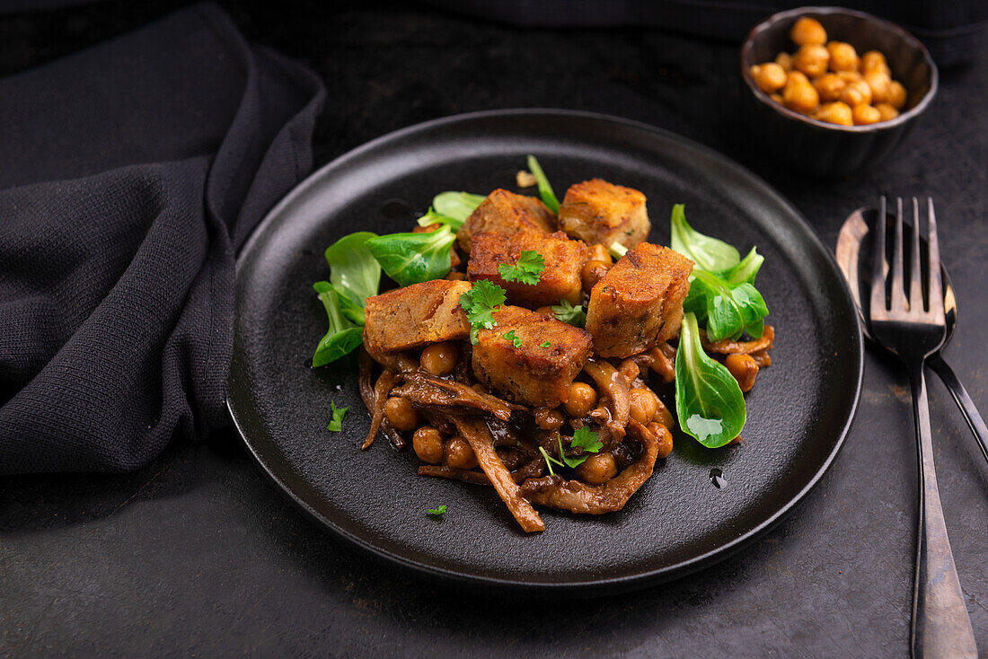 Fried bread dumplings on mushroom ragu with chickpeas and lamb's lettuce, vegan