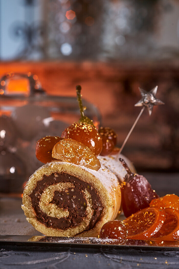 Sponge cake roll with chocolate filling and candied fruit
