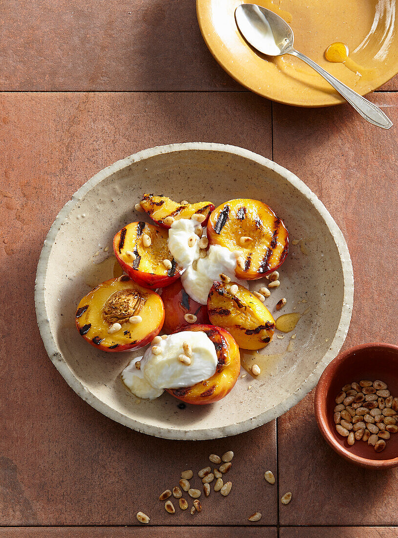 Grilled peaches with sour cream and pine nuts