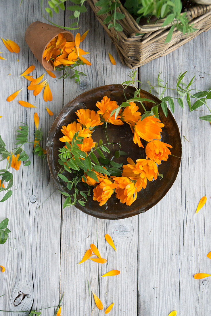 Kranz aus Ringelblumen (Calendula), Blüten auf Teller