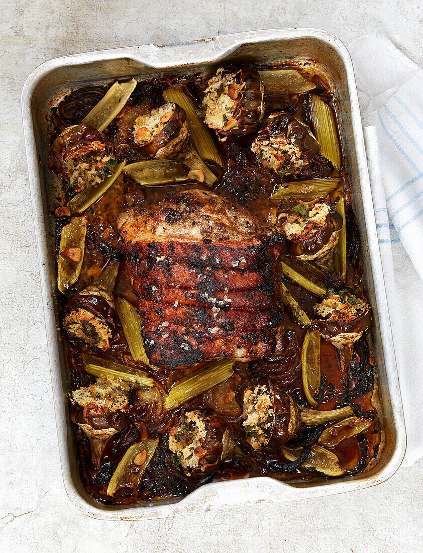 Roast pork with artichokes in a roasting tin