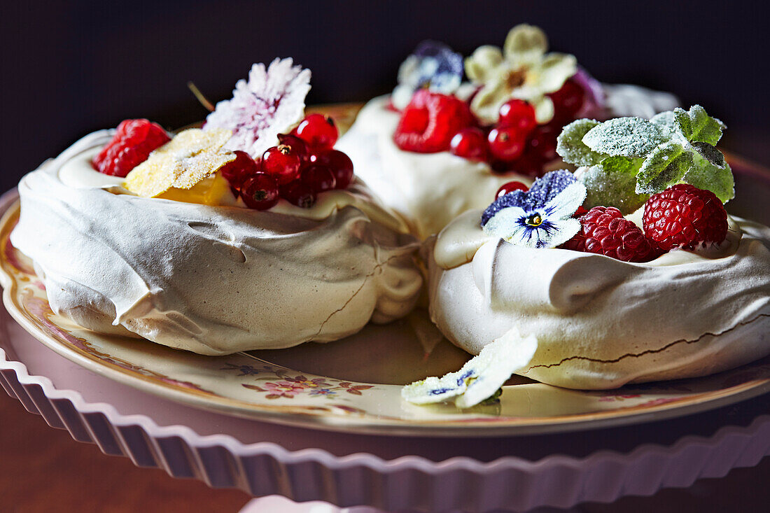 Mini-Pavlovas mit Beeren und kandierten Blüten