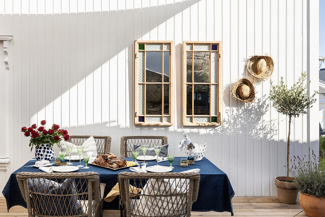 Set table with bouquet of roses under awning on terrace